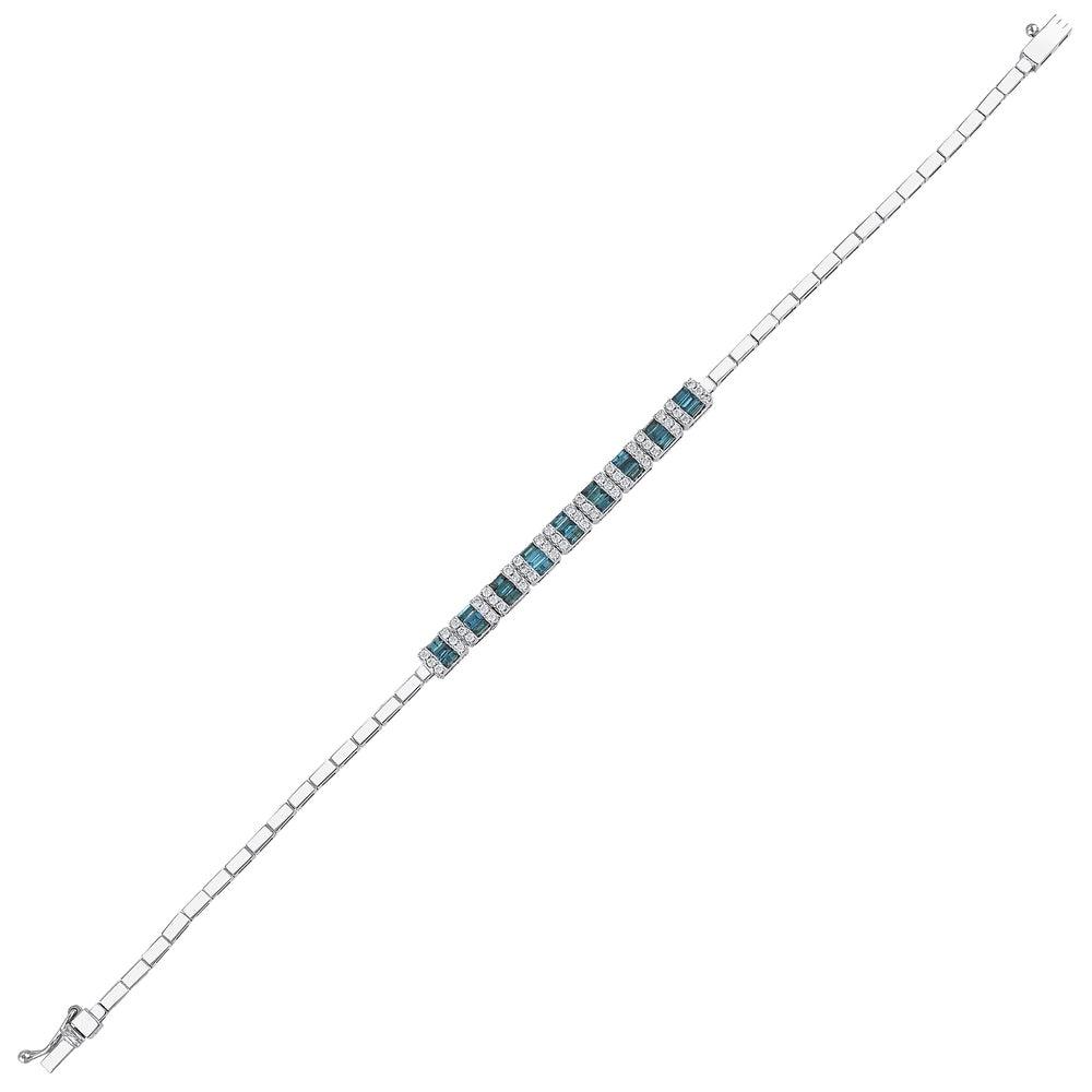 White gold tennis bracelet with alternating deep blue and clear gemstones on white background